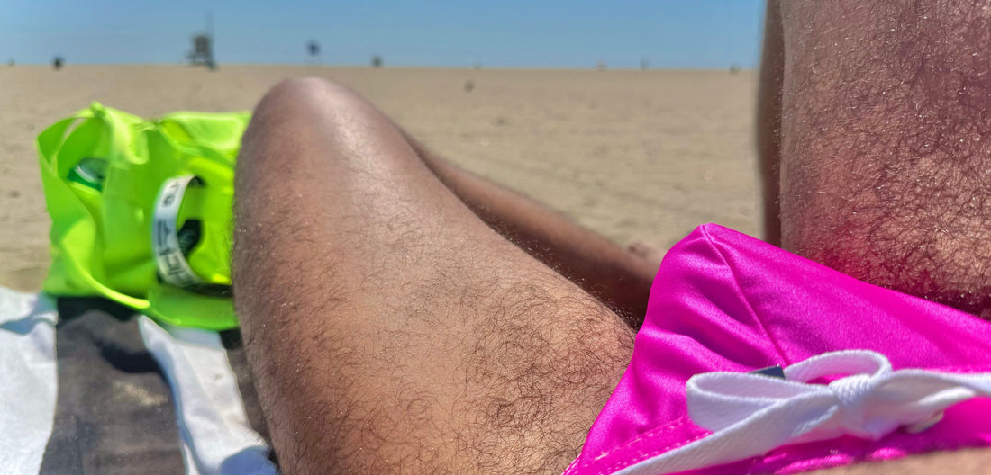 Fit, confident man in a stylish pink thong tanning on a tropical beach – ultimate beachwear inspiration for sun lovers and swimwear enthusiasts